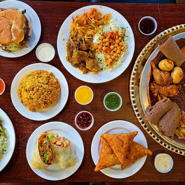 An overhead view of a table laden with various Ethiopian dishes, including injera, stews, and sides.